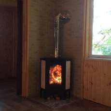 Стальной камин с большим стеклом Бавария угловая Амазонка бай фото в интерьере в Могилеве