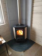 Недорогая печь-камин со стеклом Бавария угловая с плитой фото в интерьере в Могилеве