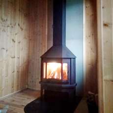 Стальной камин со стеклом Мюнхен угловой чёрный фото в интерьере в Могилеве